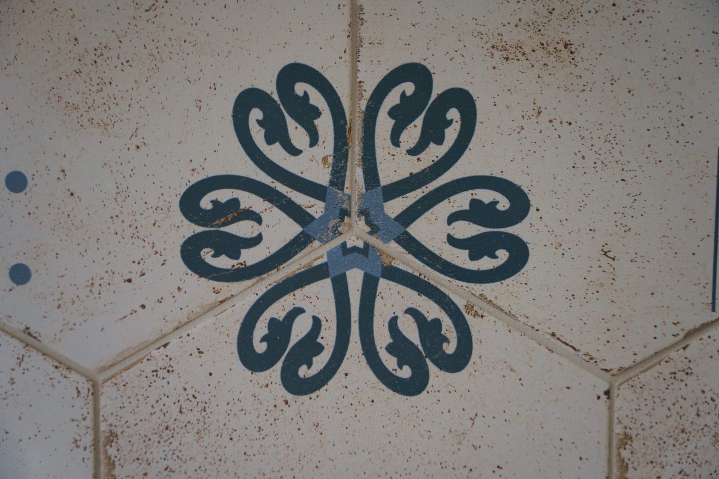 Originale sechseckige Zementfliesen, blau-graues Blumenmuster auf cremefarbenem Grund
